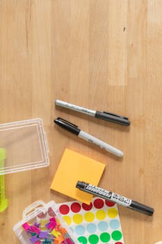 A flat lay of colorful desk stationery items on a wooden surface, perfect for office or school use.