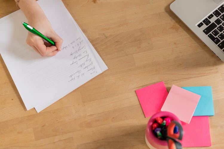 Person Writing On Bond Paper