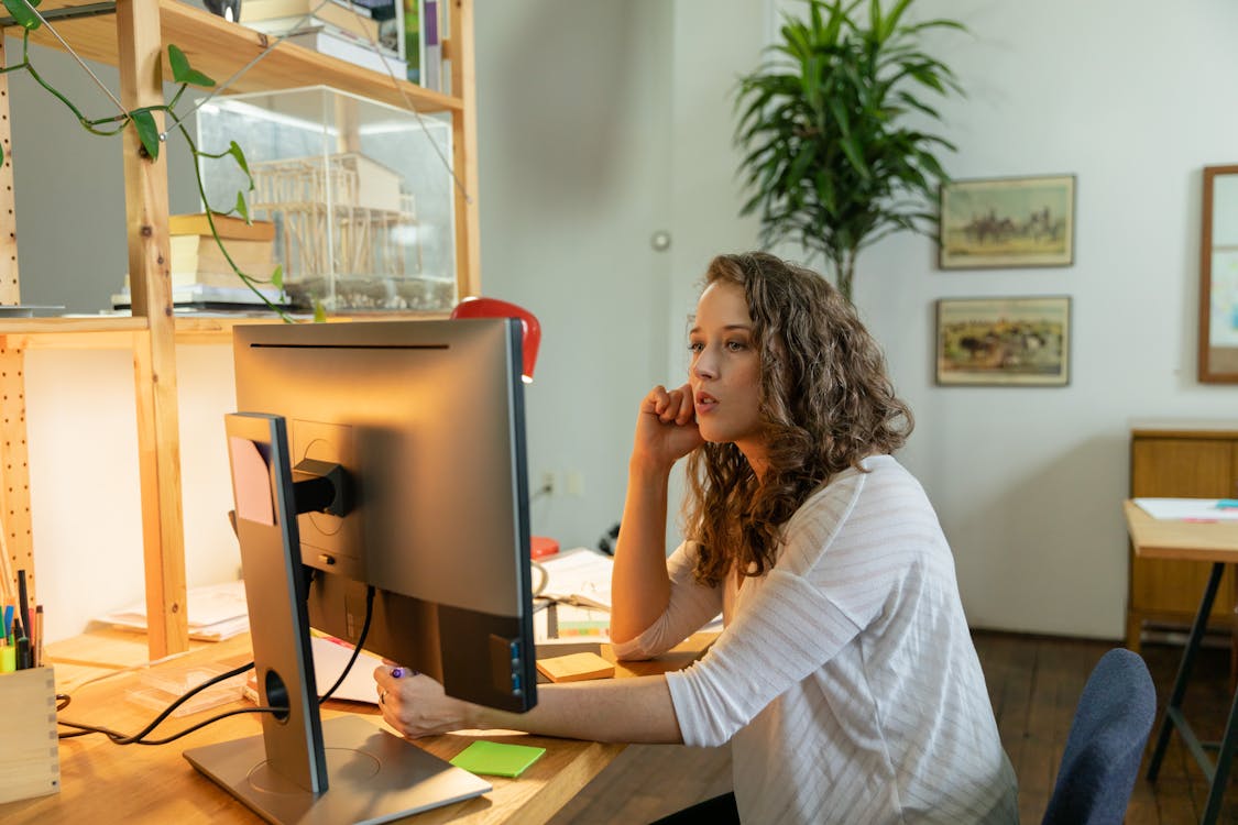 Free Woman in White Long Sleeve Shirt Sitting on Chair Stock Photo