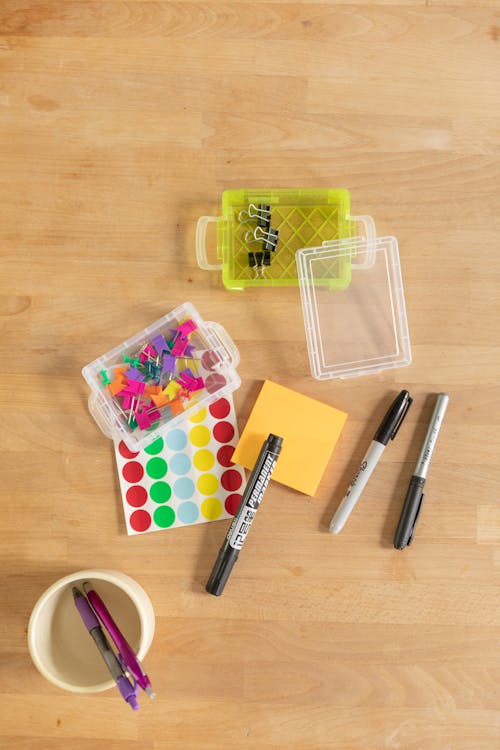 Stickers and Pens on a Wooden Table