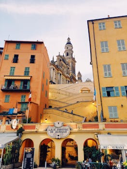 Exterior of aged residential building with ornamental balconies and facade of arched passage of store with sign
