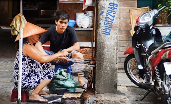 Street vendors grilling Vietnamese food outside on Hanoi's streets.