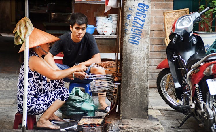 Photography Of Man And Woman Grilling Food