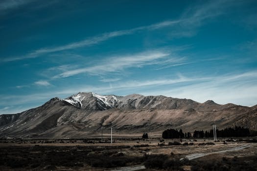 Vast landscape of a New Zealand mountain range under a clear blue sky.