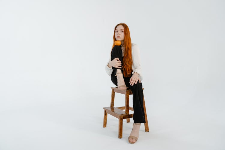 Woman Sitting On A Step Stool