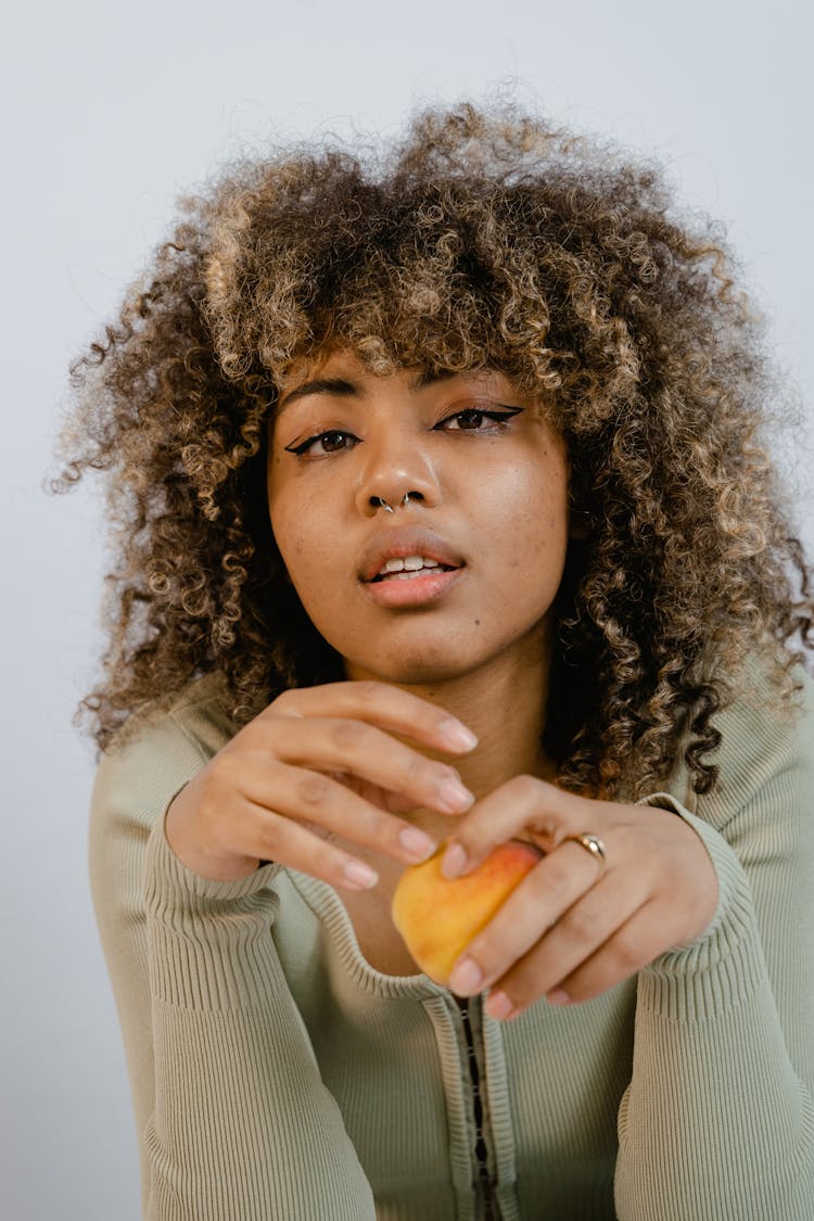 Portrait Of A Woman Holding A Fruit