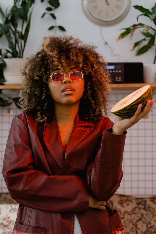 Woman in Red Leather Jacket Holding Sliced Melon