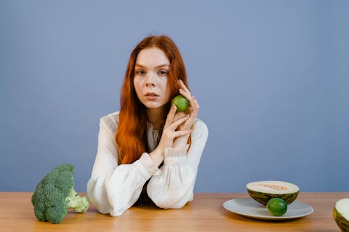 A Woman Holding a Green Lemon