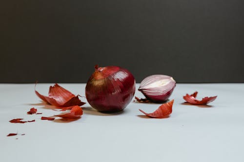 Free A Whole and Sliced Onion on a White Table Stock Photo