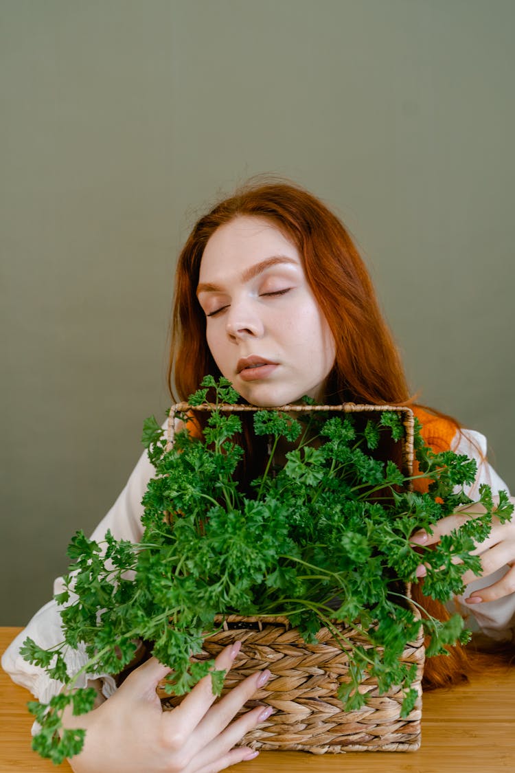 A Woman Holding A Basket With Parsley