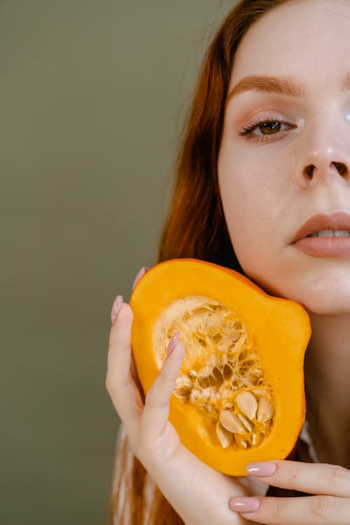 A Woman Holding a Pumpkin Cut in Half