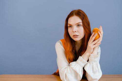 бесплатная Бесплатное стоковое фото с апельсин, белые длинные рукава, деревянный стол Стоковое фото