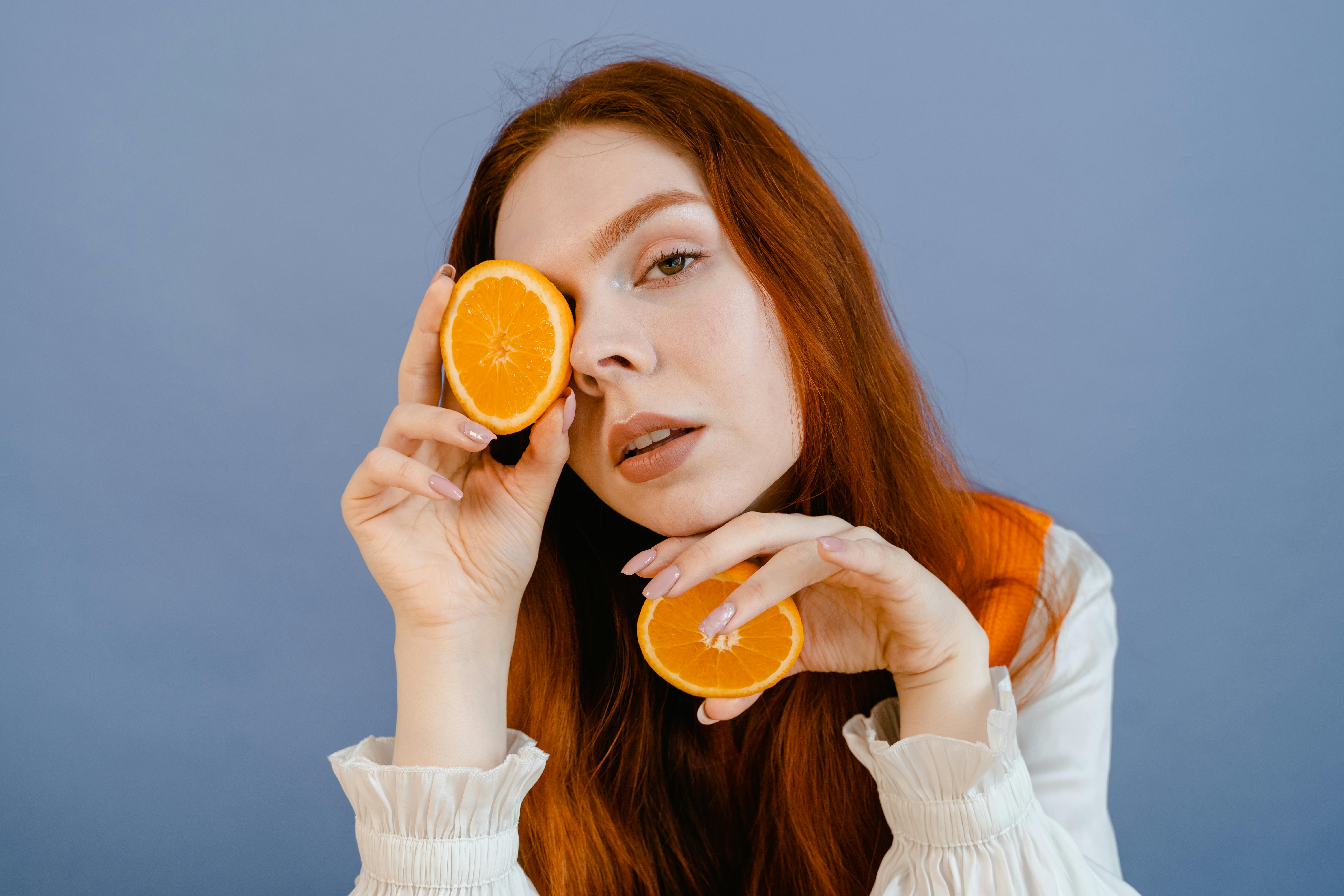 woman holding sliced orange fruit