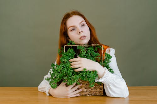 Woman Holding a Basket with Green Vegetables