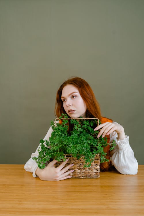 Free Woman in White Long Sleeve Shirt Holding Green Plant Stock Photo