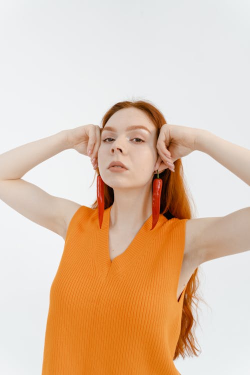 Woman in Orange Sleeveless Shirt Hold Red Chilis