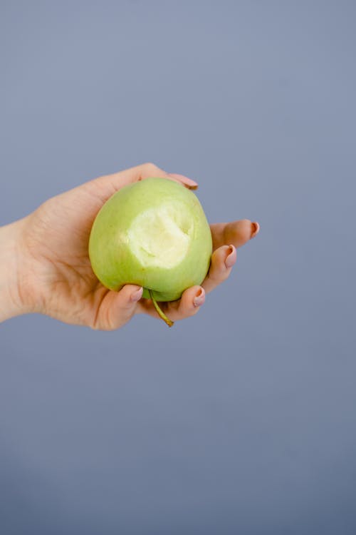 Person Holding a Green Apple