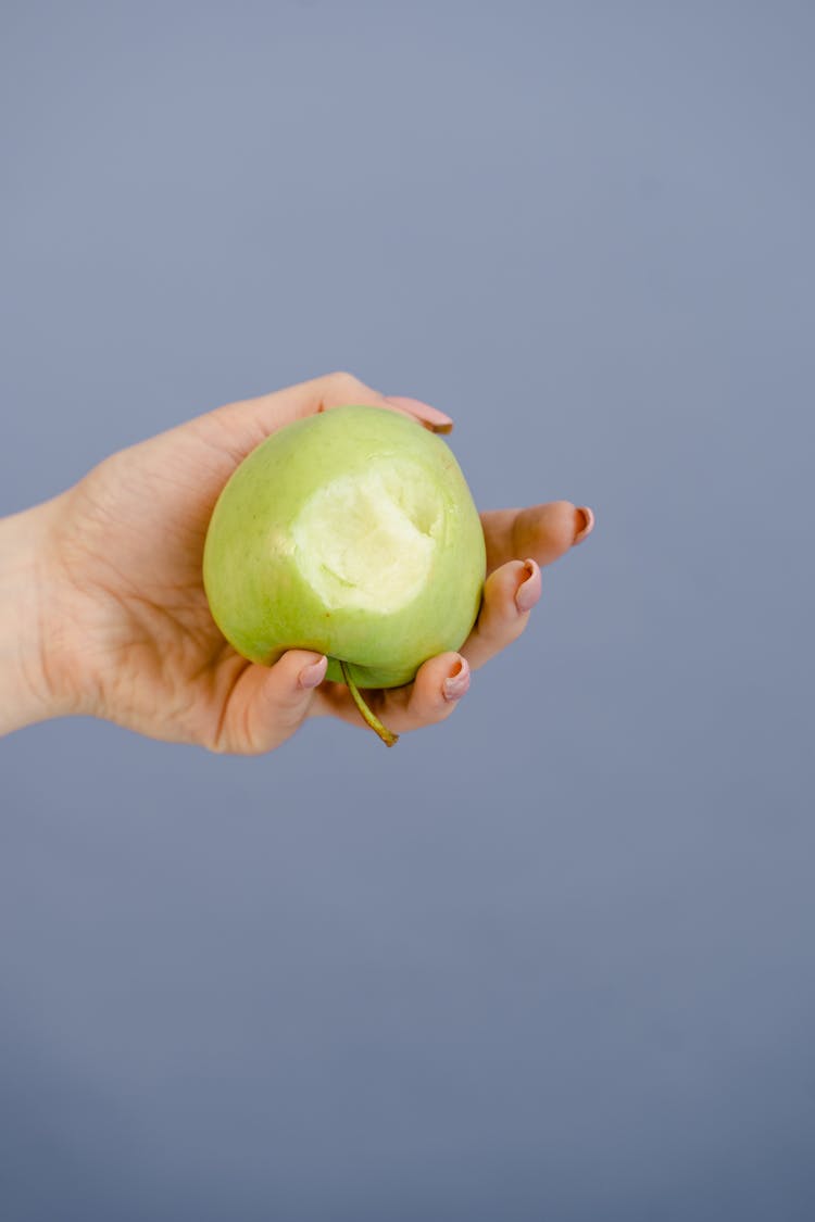 Person Holding A Green Apple