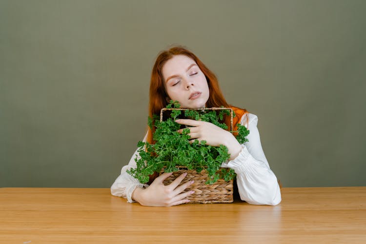 A Woman Grasping A Basket Of Parsley