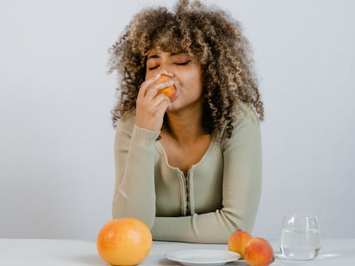 Curly Woman Eating Fruits