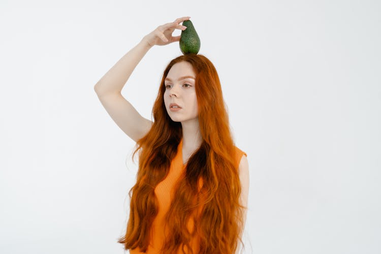 Woman Putting A Green Vegetable On Her Head