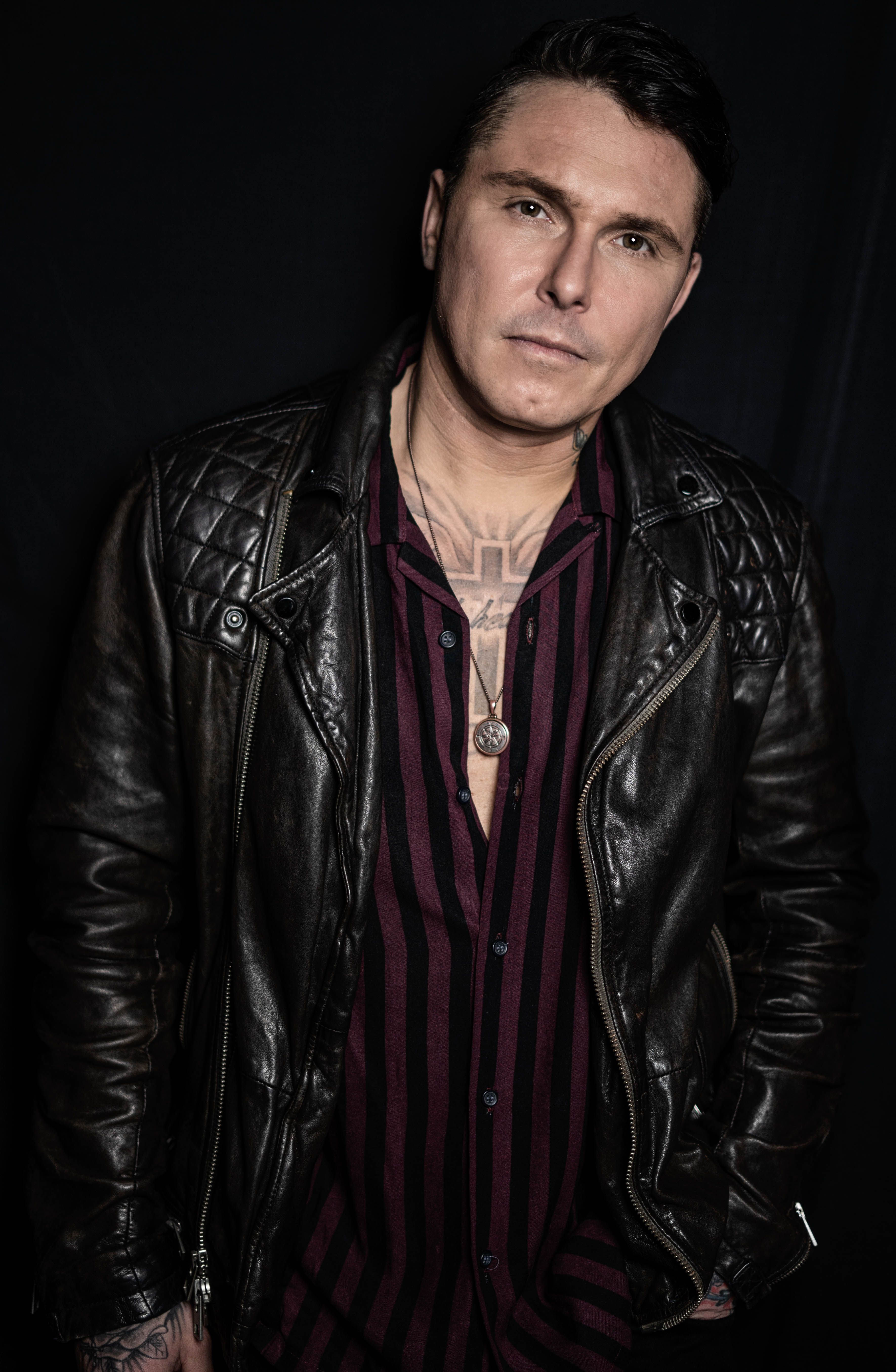 Portrait of a man in a leather jacket, showcasing a modern, grunge fashion look.