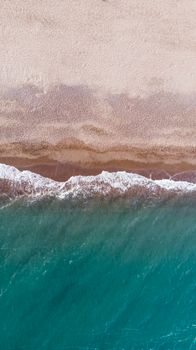 Stunning aerial view of Antalya's turquoise waters meeting sandy shores, capturing the beauty of Türkiye's coastline.