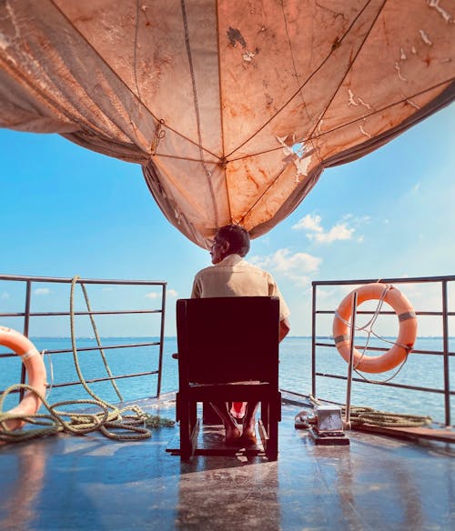 A Man Sitting on a Mounted Chair in a Boat