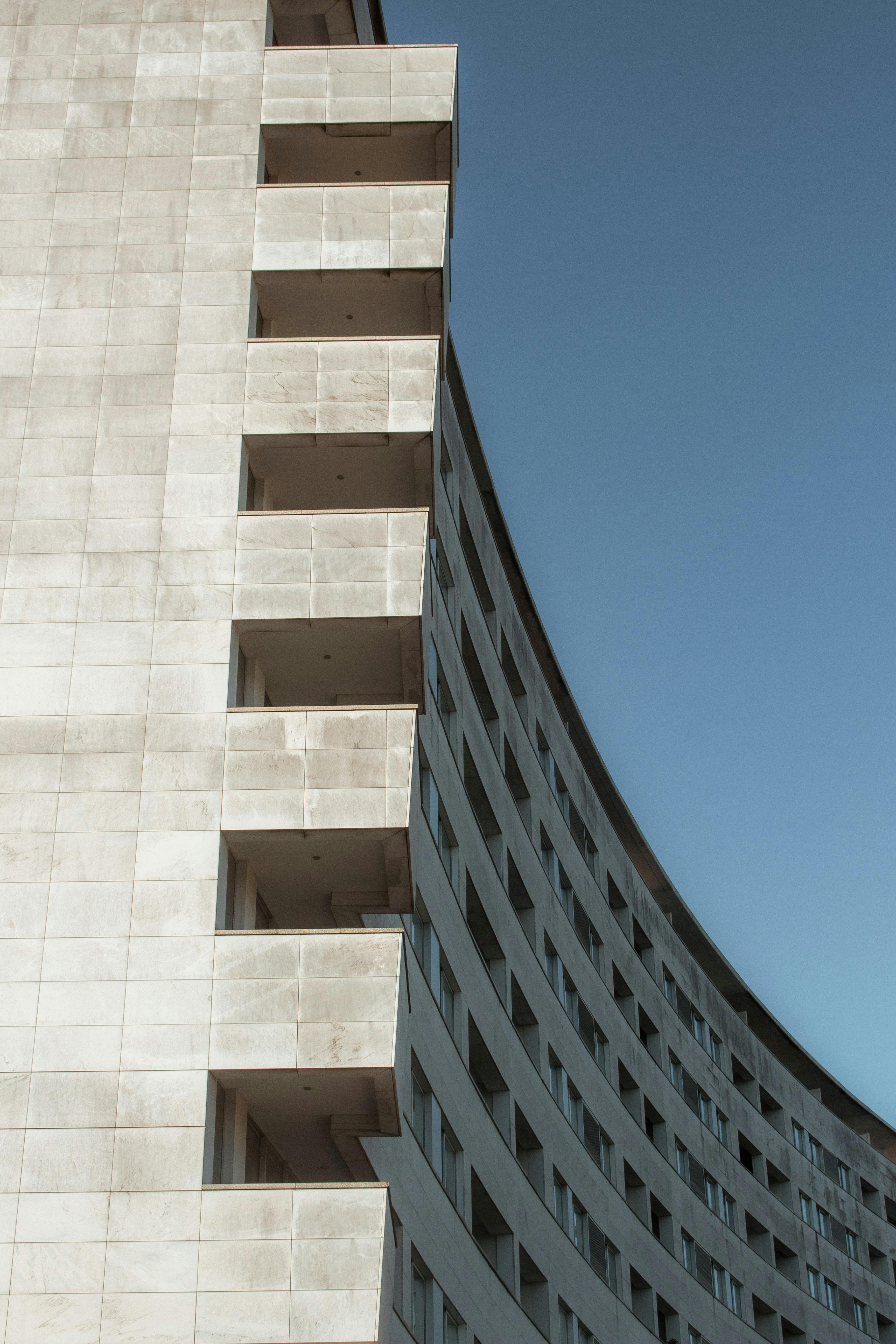 Curved architectural facade of a modern high-rise in Porto, Portugal captured from a low angle.