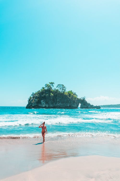 A Woman in a Bikini Walking at the Beach