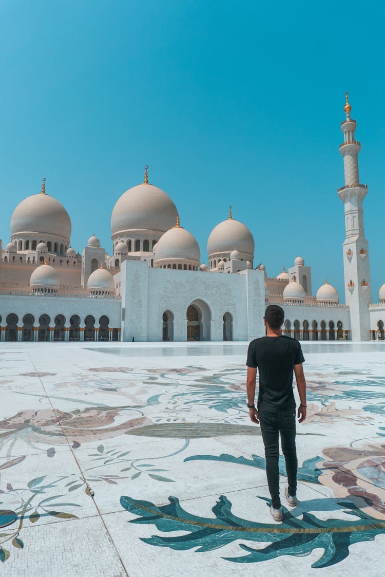 A Man Standing On The Grounds Of The Sheik Zayed Grand Mosque