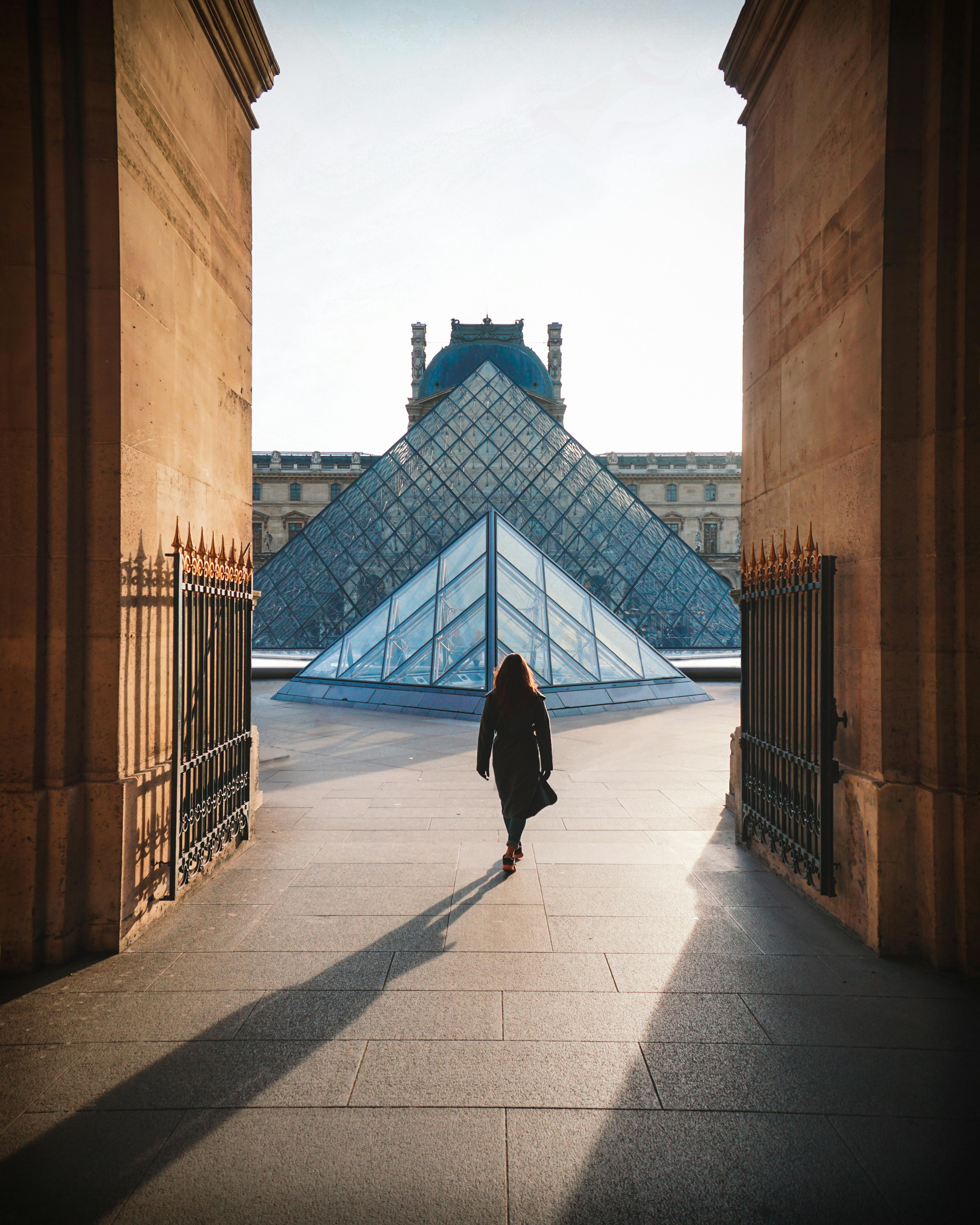 woman in black dress walking on sidewalk