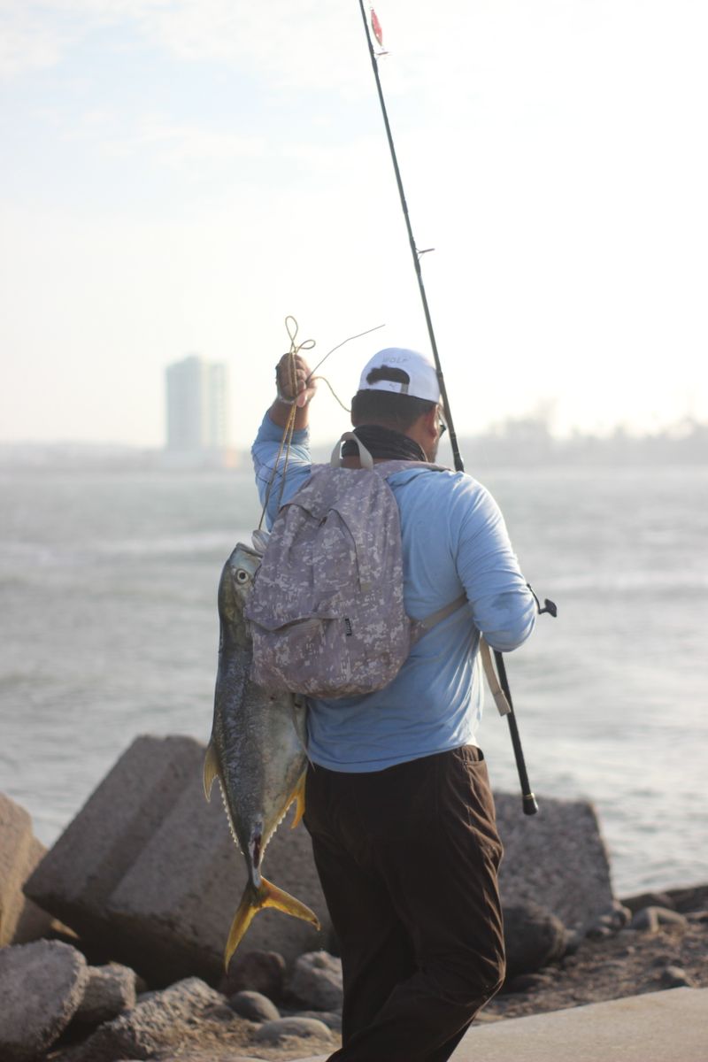 Angler holding up a fresh reef catch on the jetty