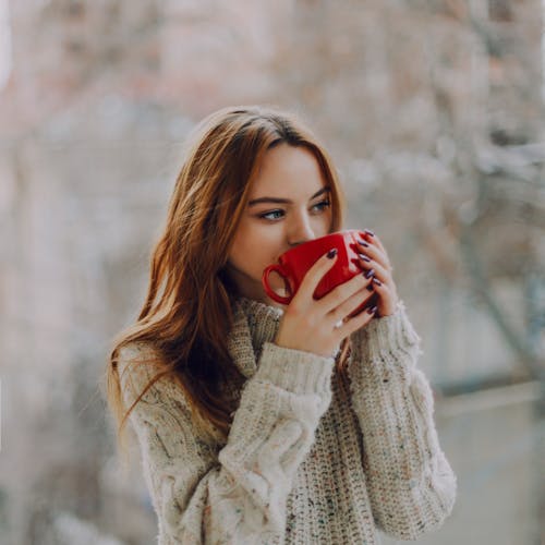 Free Selective Focus Photography of Woman Holding Red Ceramic Cup Stock Photo