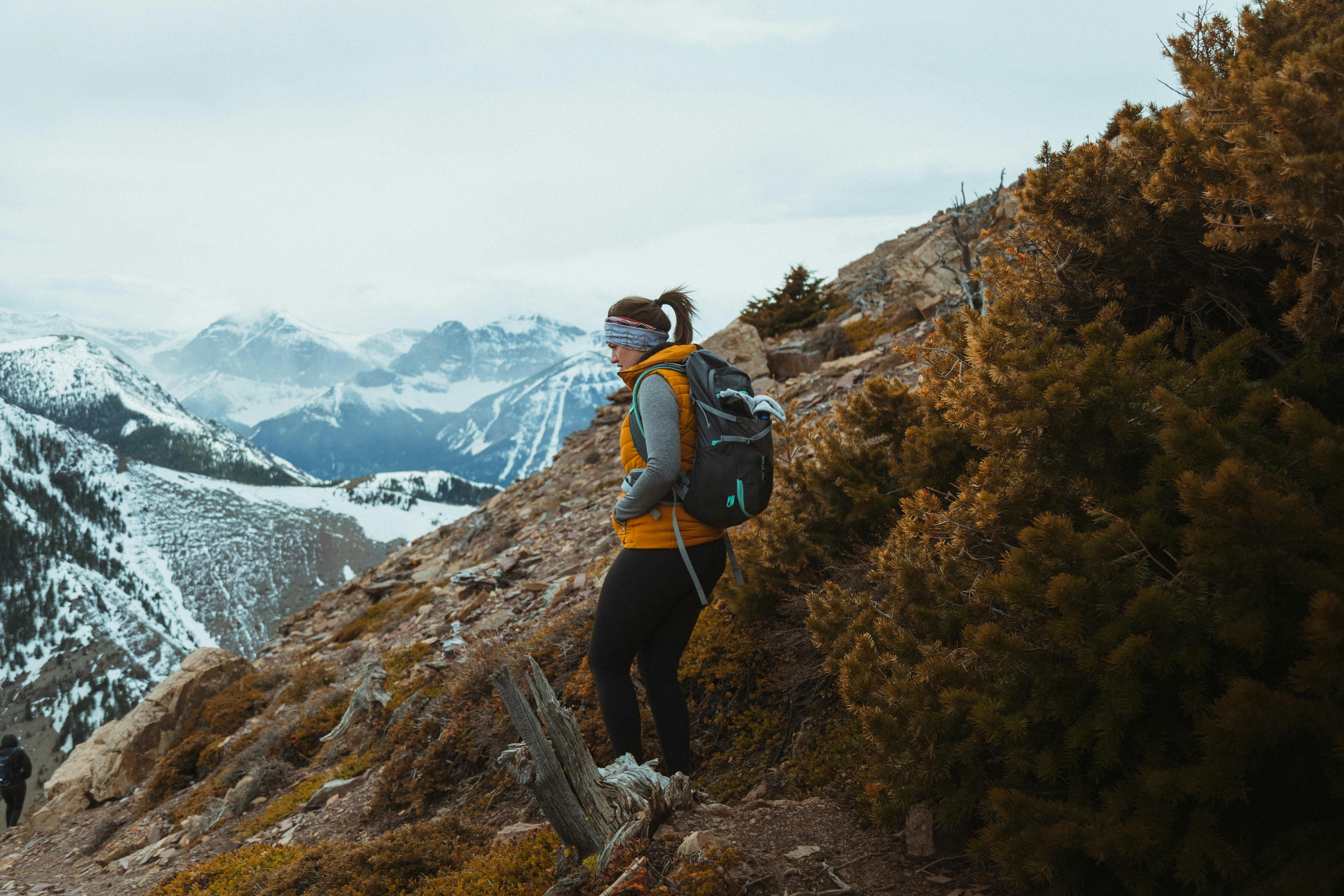 Woman solo traveler sitting quietly with a backpack in a scenic outdoor setting