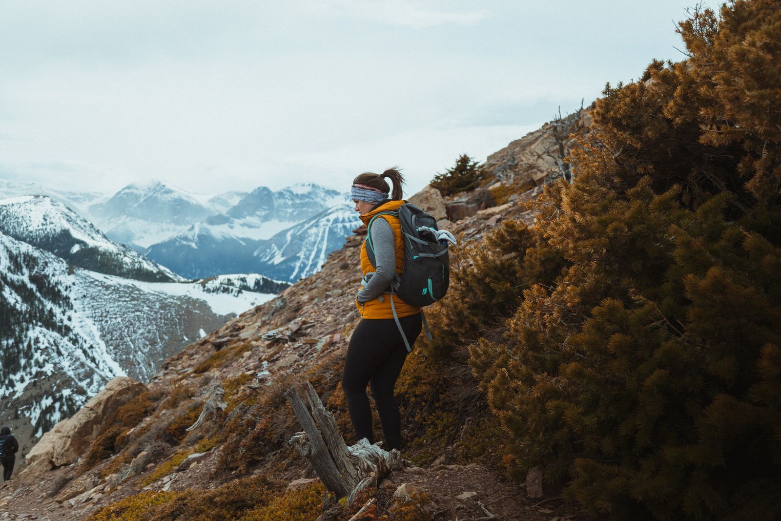 Woman solo traveler sitting quietly with a backpack in a scenic outdoor setting