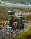 Flask, Mug and Portable Kettle Flame on the Ground