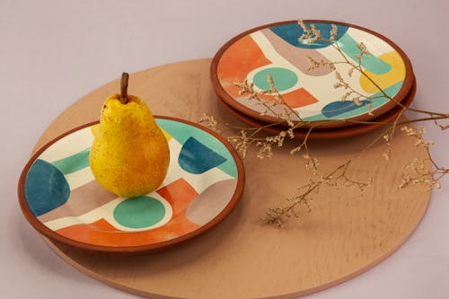 A Pear Fruit on a Colorful Plate on Wooden Tray