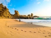 在印度尼西亚东爪哇岛的克拉亚尔海滩上，一个人沿着沙滩奔跑，在明亮的天空下留下了脚印