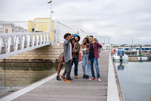 People Standing on Boardwalk Taking Group Selfie
