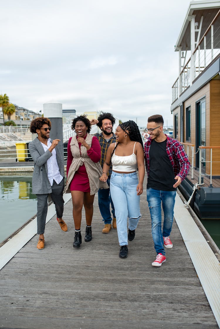 Group Of Happy People Walking On Boardwalk