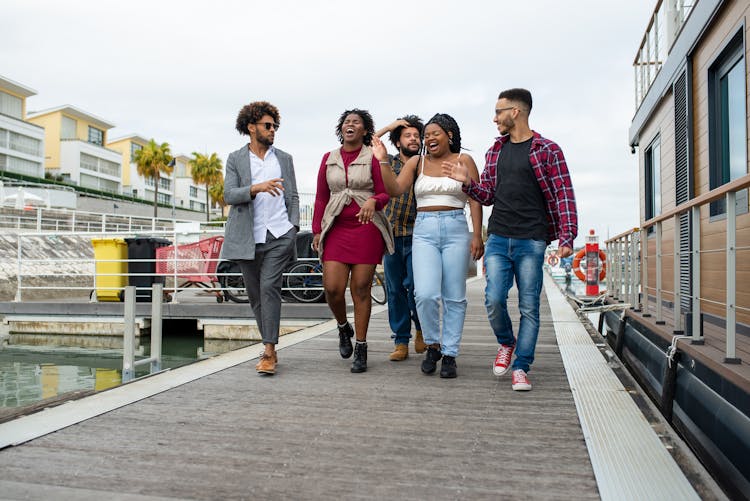 Group Of Happy People Walking On Boardwalk