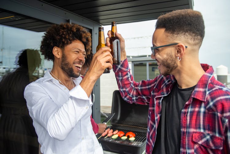 Two Men Clinking Beer Bottles