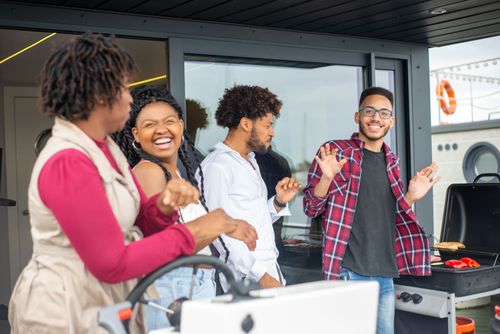 Free Group of friends laughing and grilling together outdoors, enjoying a sunny day in Portugal. Stock Photo