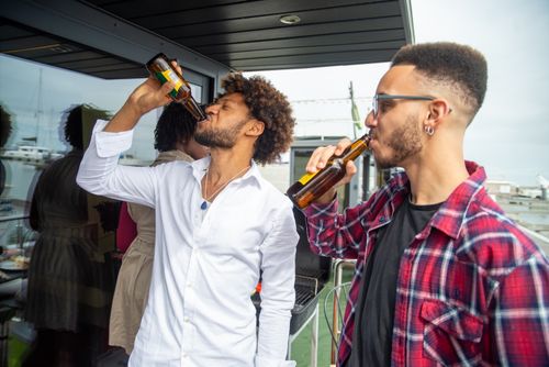 Free African American men enjoying drinks at an outdoor party on a patio with a view. Stock Photo