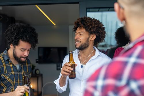Free Casual gathering of friends sharing a drink indoors, enjoying leisure time. Stock Photo