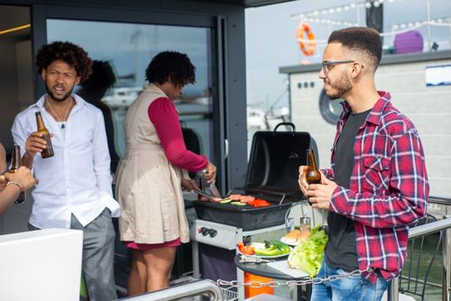 Free Group of friends enjoying a barbecue party outdoors with drinks and laughter. Stock Photo