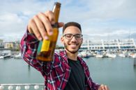Man in Black and Red Plaid Dress Shirt Holding Beer Bottle