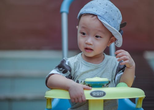 Free Boy Sitting on Yellow and Blue Trike Stock Photo