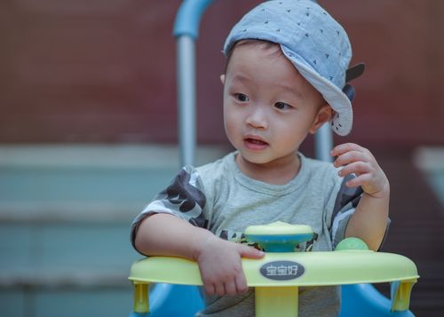 Toddler riding a yellow and blue tricycle outdoors